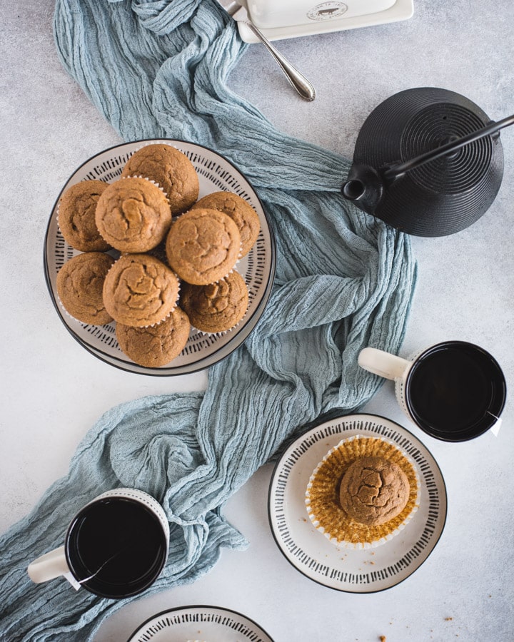 overhead picture of plate of pumpkin muffins with cups and teapot