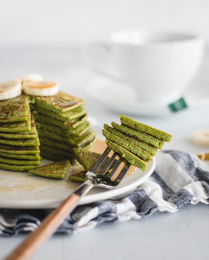 stack of green pancakes with a fork stabbing a bite 