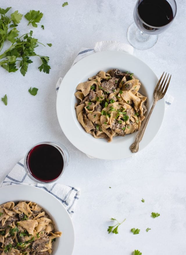 overhead picture of two bowls of beef stroganoff on white background