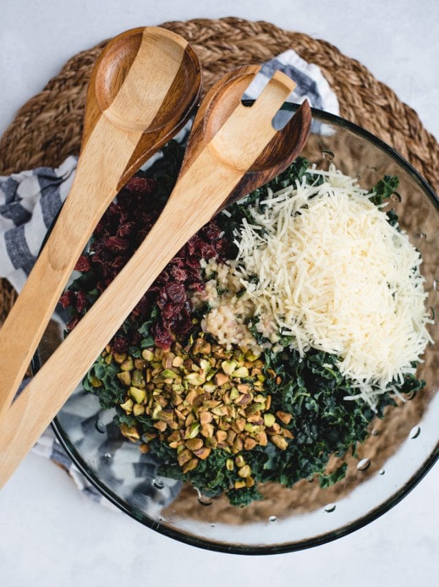 overhead picture of kale salad with parmesan, cranberries, and pistachios on top