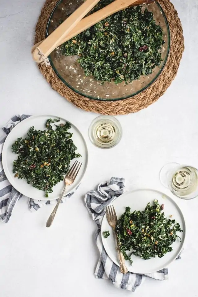 overhead picture of two plates of kale salad with wine