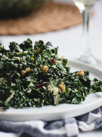 close up picture of kale salad on a white plate