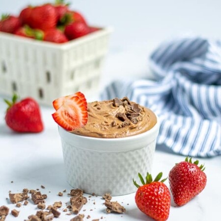 white bowl with chocolate hummus and strawberries