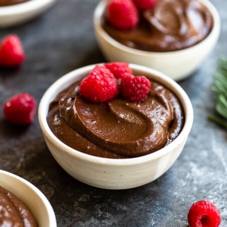 bowl of chocolate mousse with raspberries on dark background
