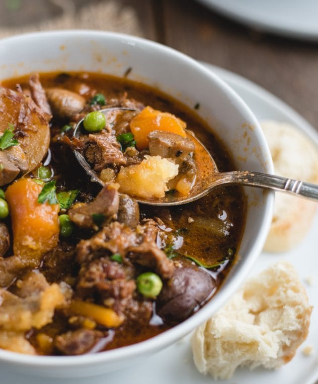 close up picture of spoon resting in bowl of irish stew