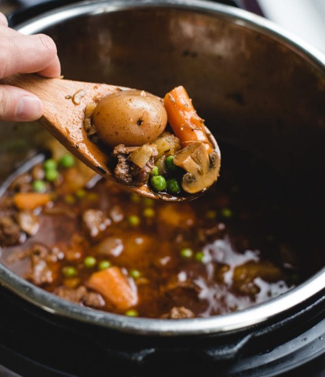 spoonful of irish stew held over an instant pot