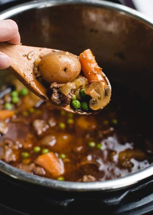 spoonful of irish stew held over an instant pot