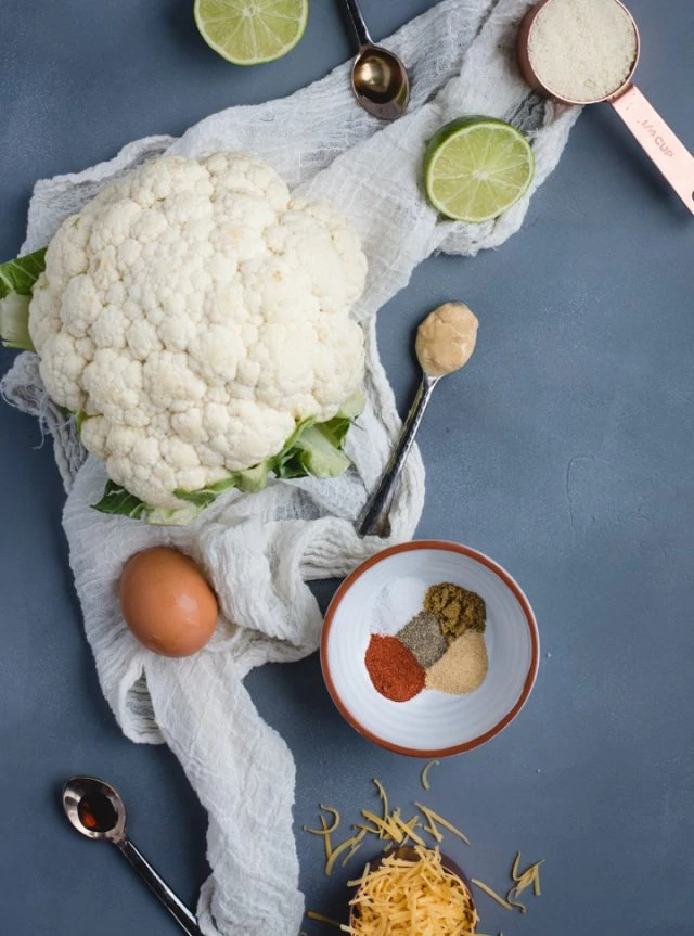 overhead picture of cauliflower, lime, and other cauliflower fritter ingredients
