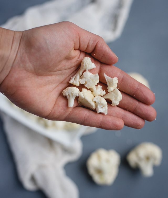 hand holding chopped up cauliflower florets