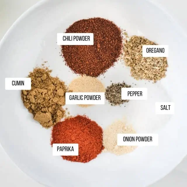 picture of chicken taco seasoning ingredients all labeled separately in a white bowl