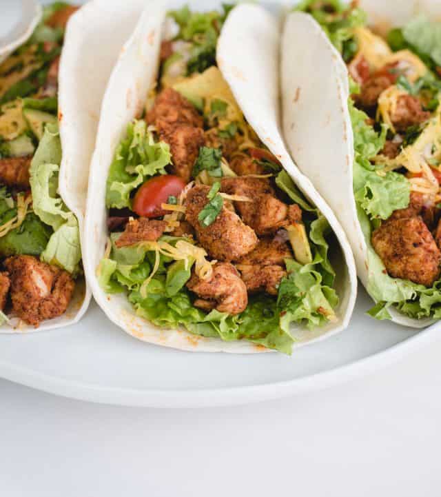 up close picture of chicken tacos on a plate