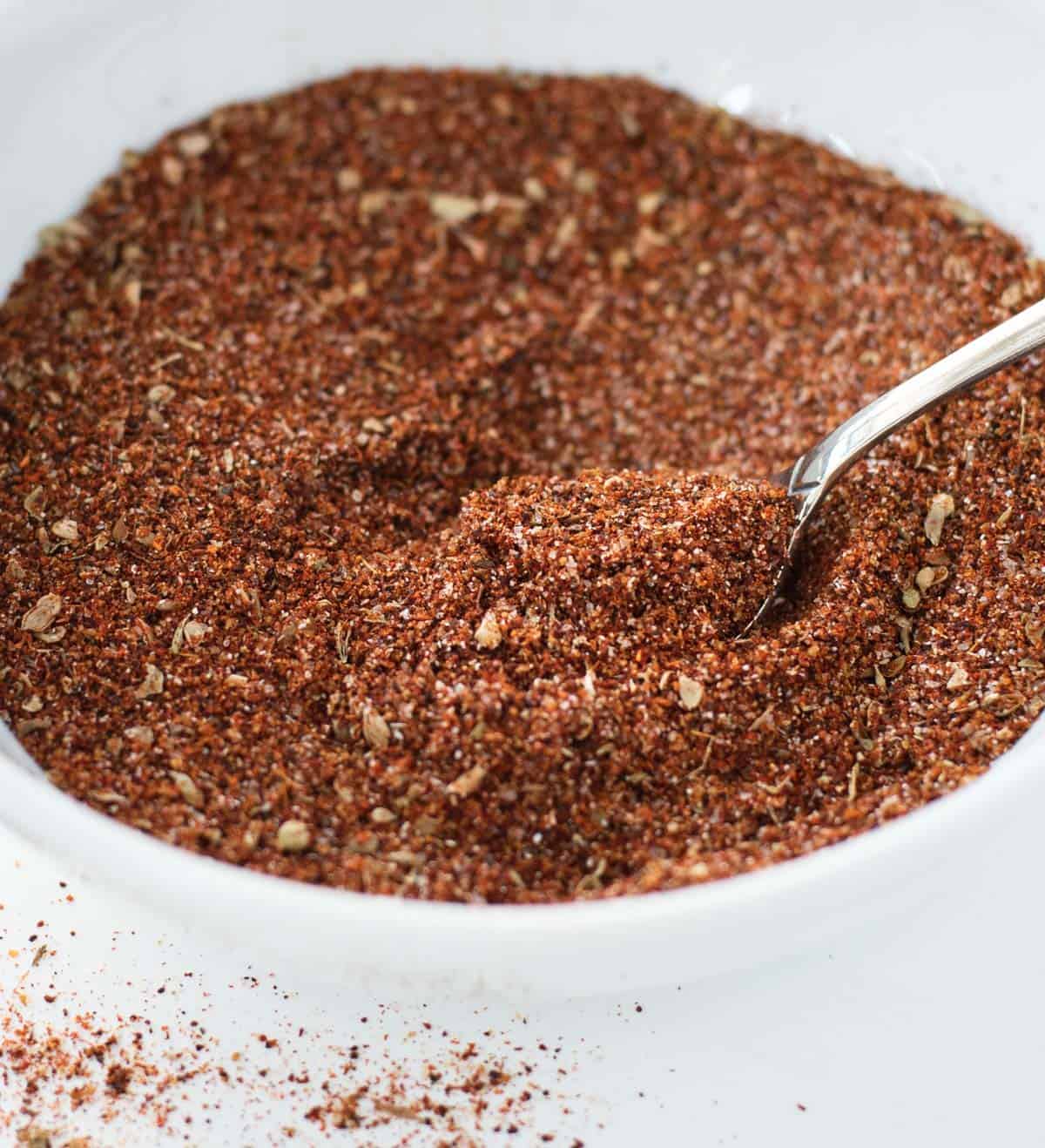 taco seasoning in a white bowl with a spoon in it