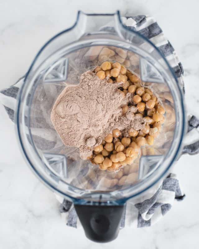 blender with chocolate protein powder and chickpeas in it