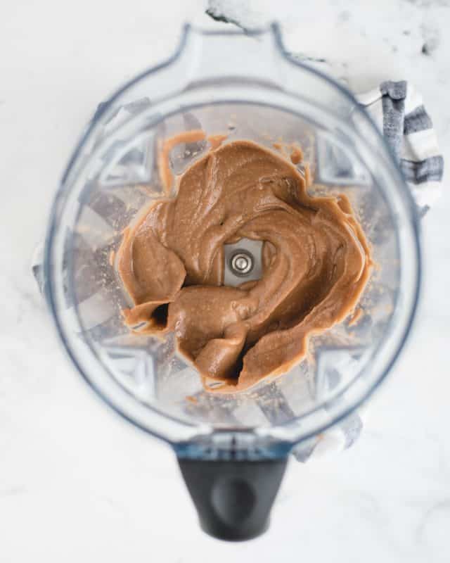 blender with blended up chocolate hummus in it
