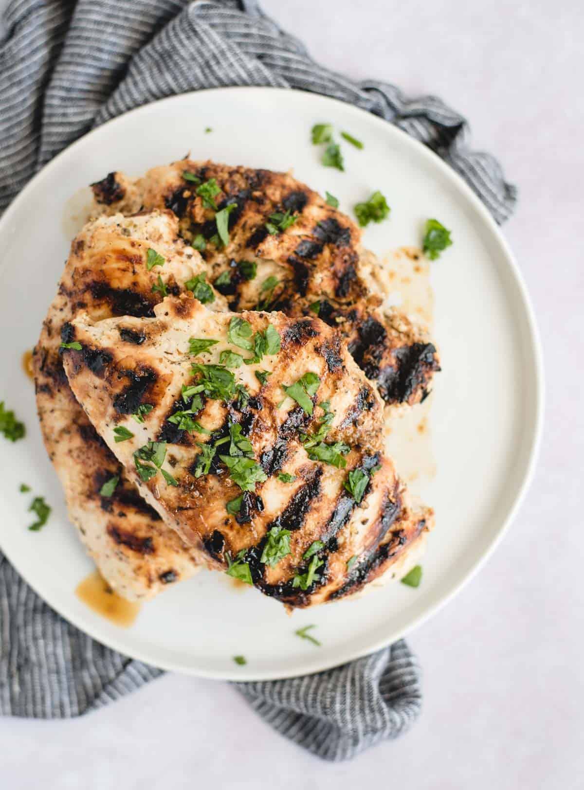 overhead picture of grilled chicken breasts on a white plate