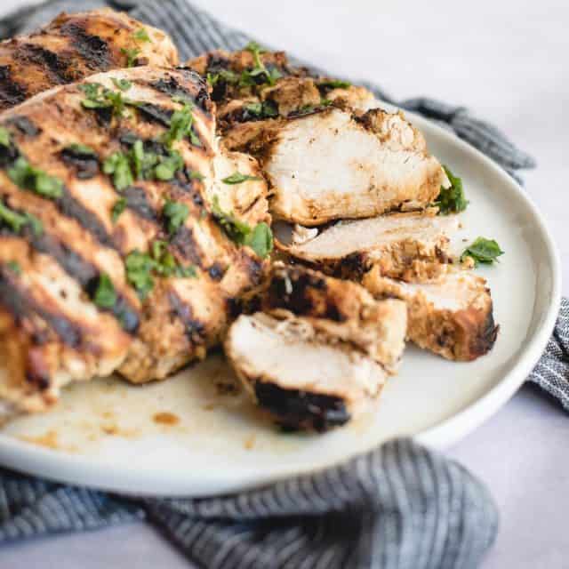 close up picture of sliced grilled chicken topped with parsley