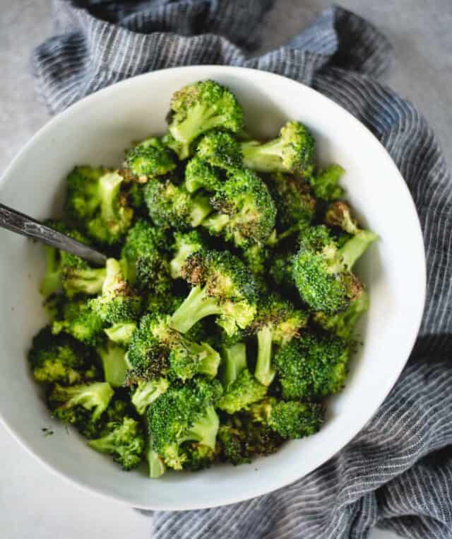 white bowl of cooked broccoli from overhead angle 