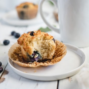 almond flour blueberry muffin on a plate with bite taken out