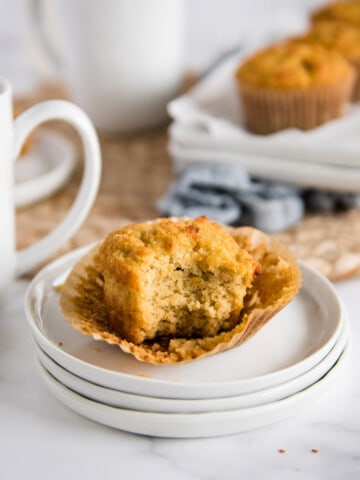 coconut muffin on a white plate with bite taken out