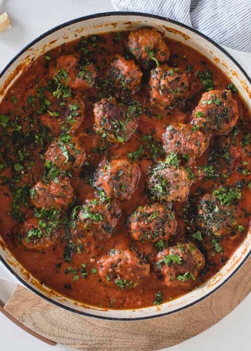 overhead picture of a pan full of bison meatballs covered in a red sauce