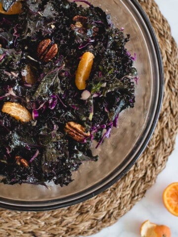 kale salad with mandarin oranges and pecans in it