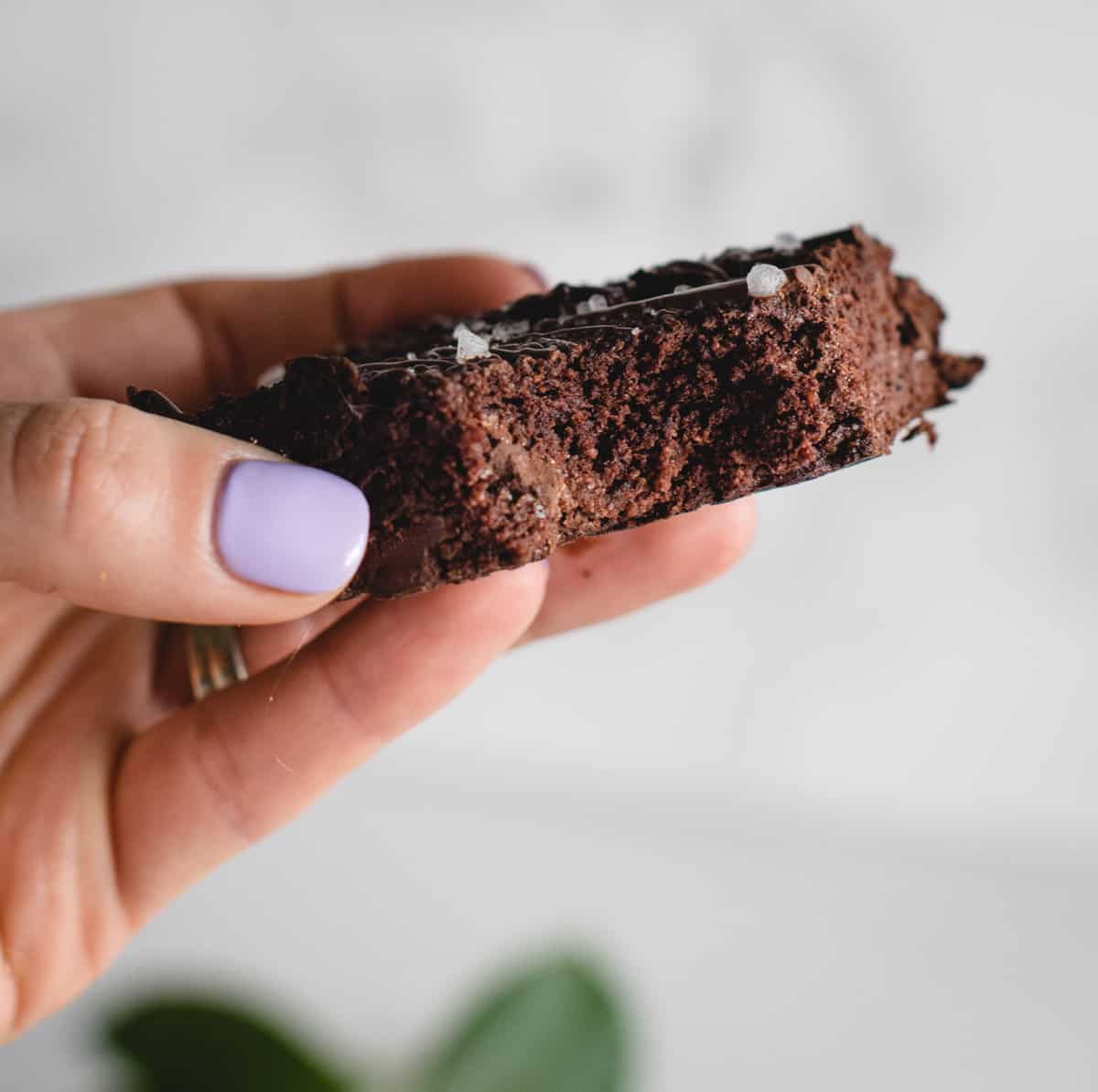 hand holding healthy banana brownie with a bite taken out of it