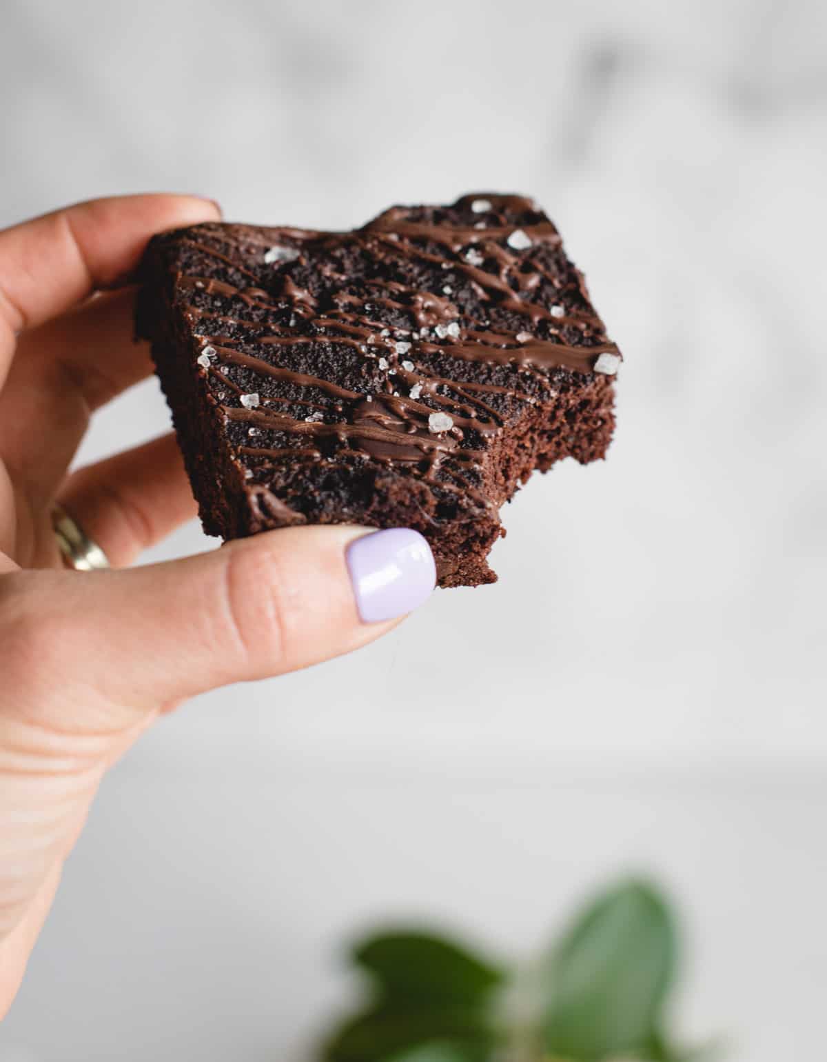 Close up of hand holding gluten free salted banana brownie