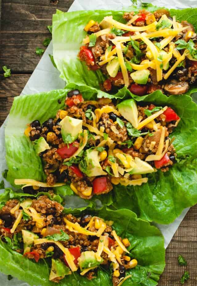 angled close up image of three taco vegetarian lettuce wraps on a wood backdrop