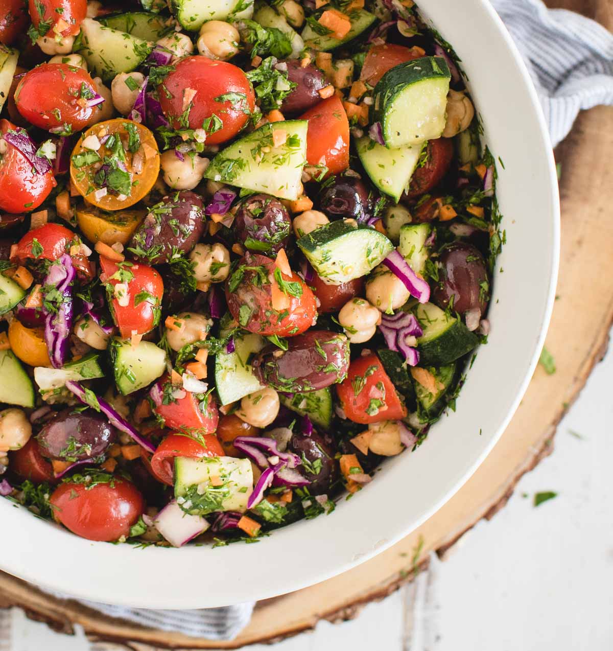 overhead close up picture of mediterranean vegan chickpea salad in a white bowl