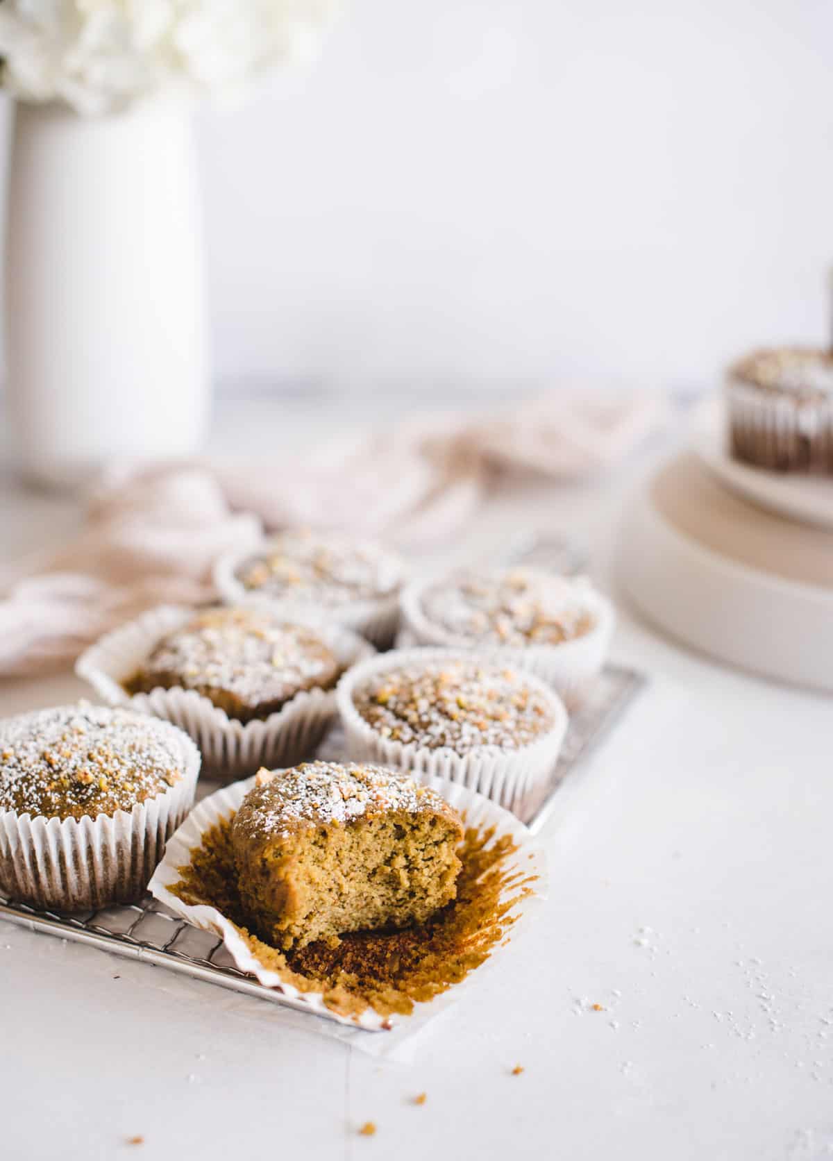 Muffin on a white background with other muffins and flowers in background