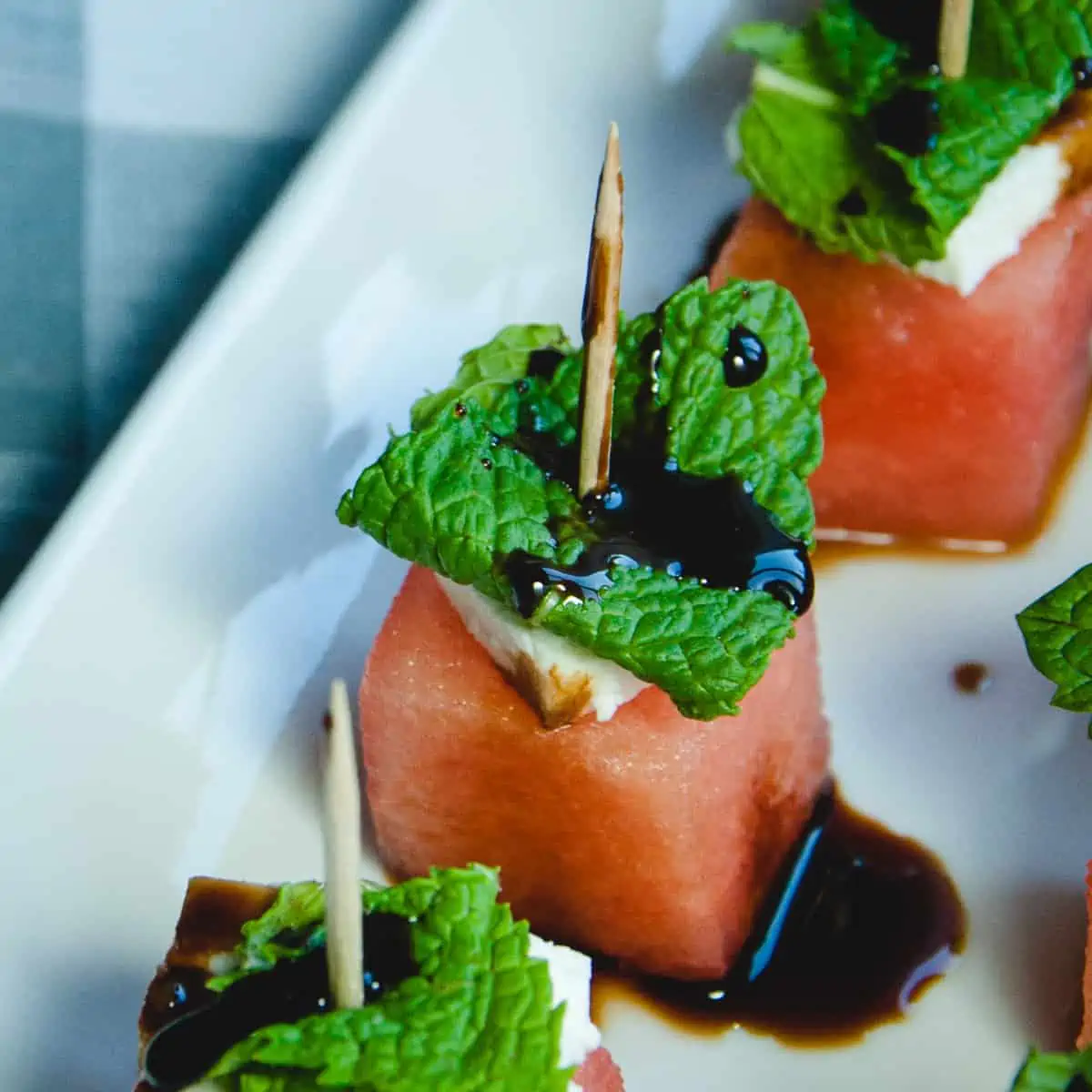 Close up picture of a watermelon mint toothpick skewer with balsamic glaze