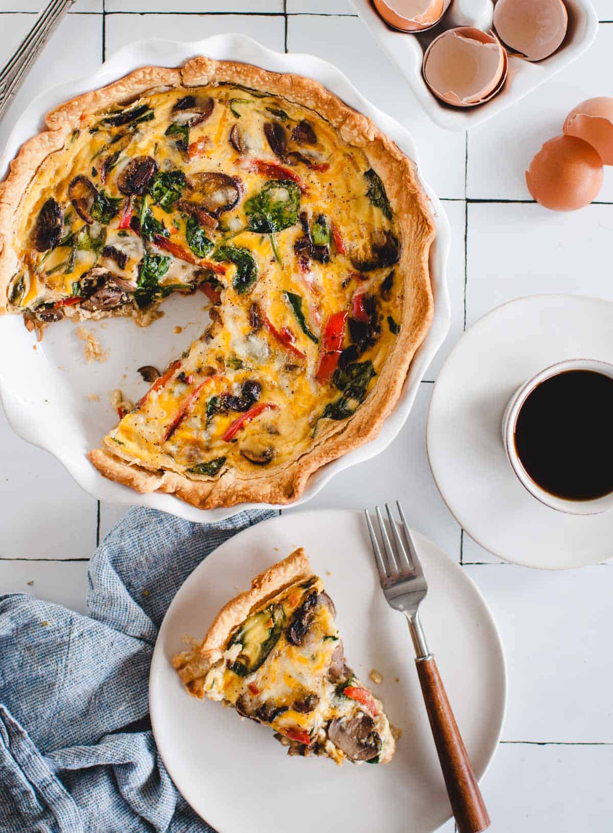 overhead of vegetable quiche on a white background