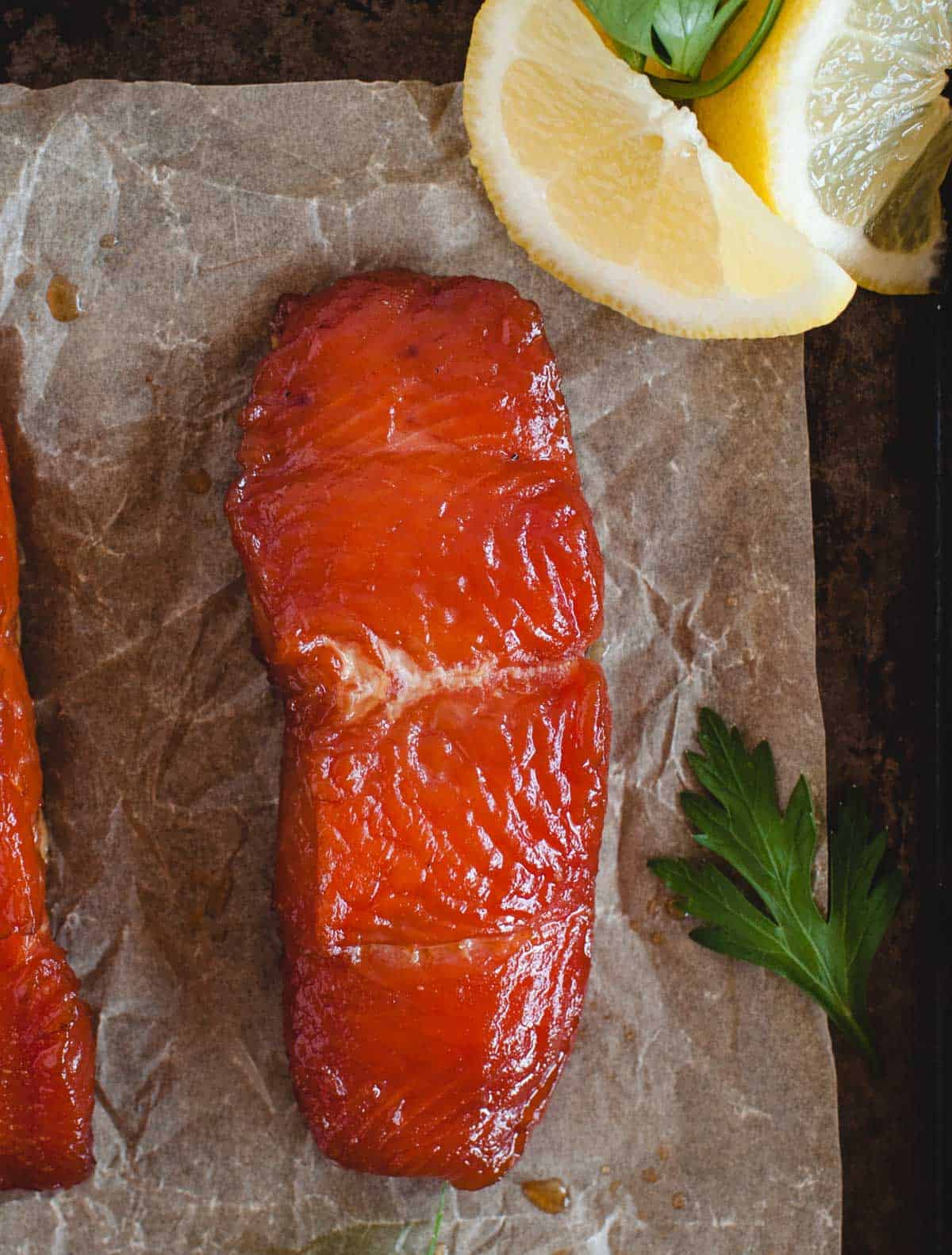 overhead close up of strip of smoked salmon with parsley and lemon wedge