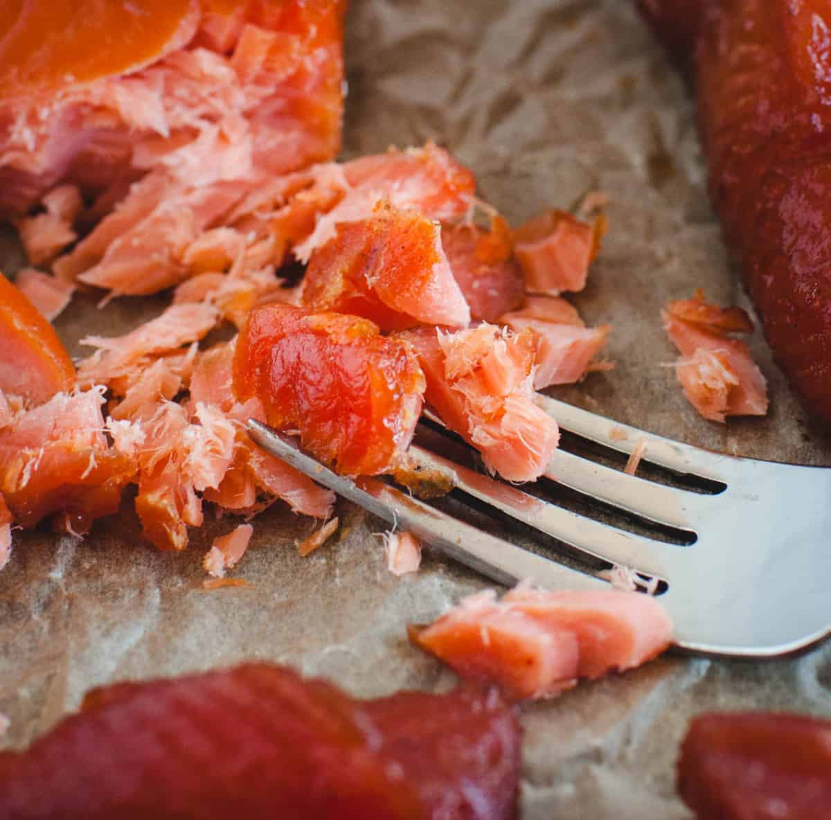 close up of a fork with smoked salmon on it