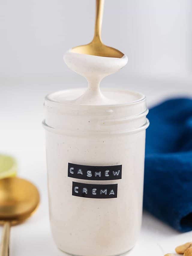 cashew crema being drizzled form spoon into jar