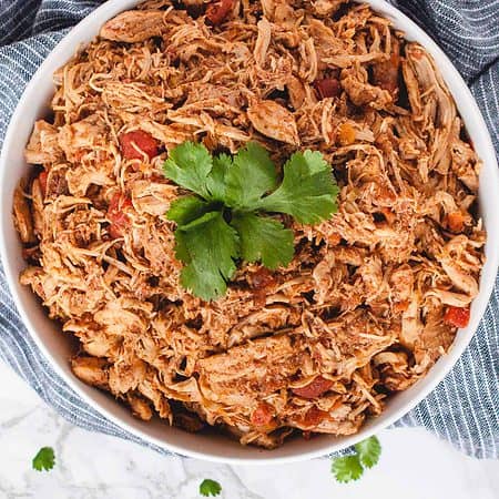 close up overhead of shredded taco chicken in a bowl