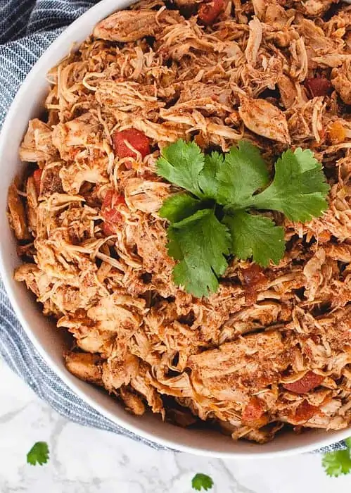 close up overhead of shredded taco chicken in a bowl