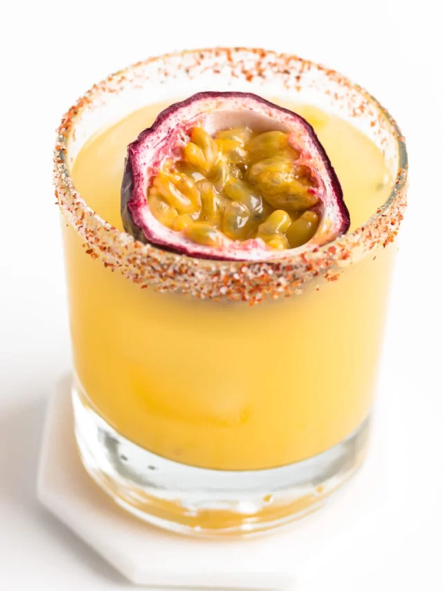margarita on the rocks with passion fruit floating in it
