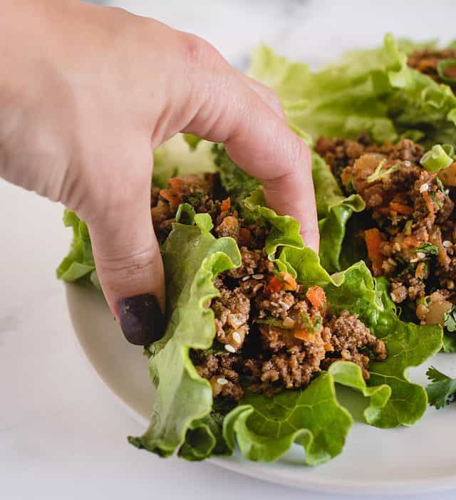 hand holding ground beef lettuce wrap