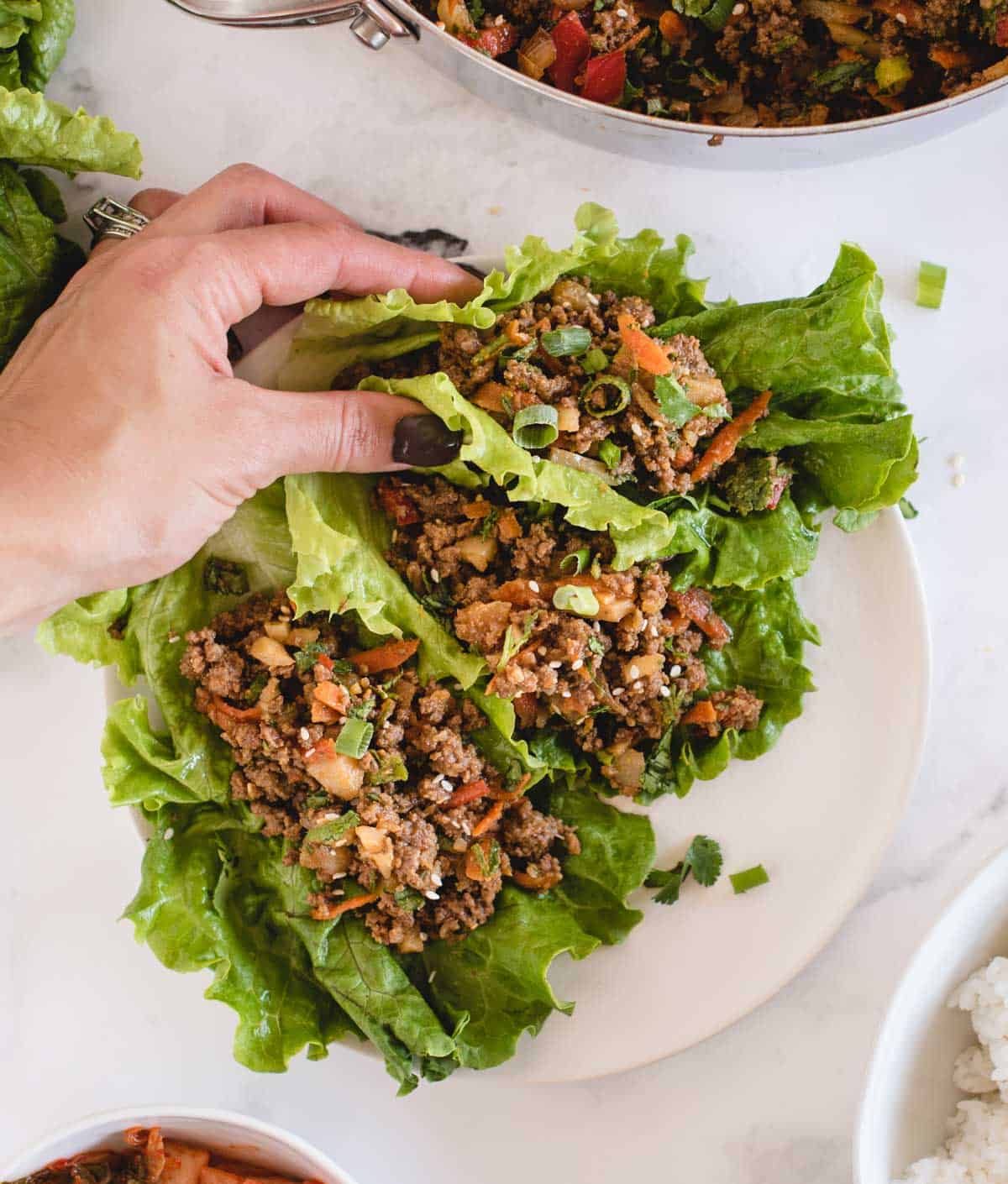 hand holding ground beef lettuce wrap from overhead