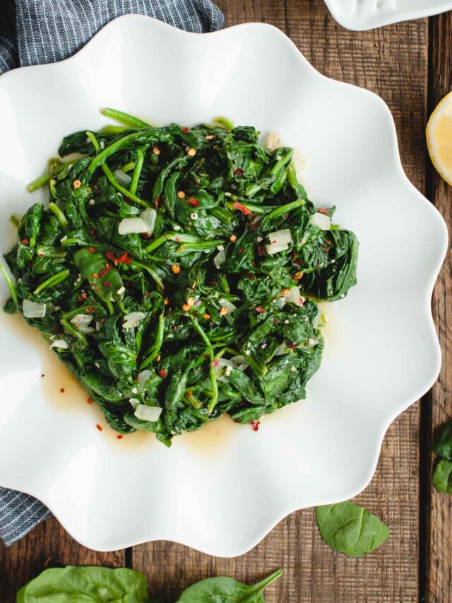 vertical image of cooked spinach on a serving platter