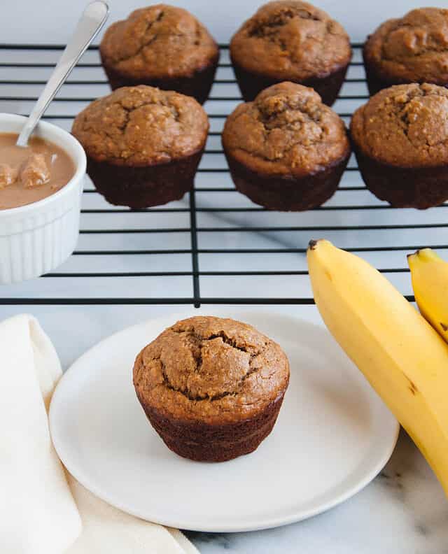muffins next to a bowl of peanut butter and bananas