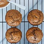 four peanut butter banana muffins on a cooling rack
