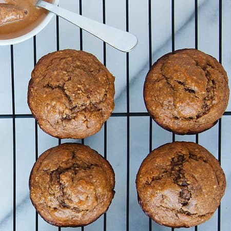 four peanut butter banana muffins on a cooling rack