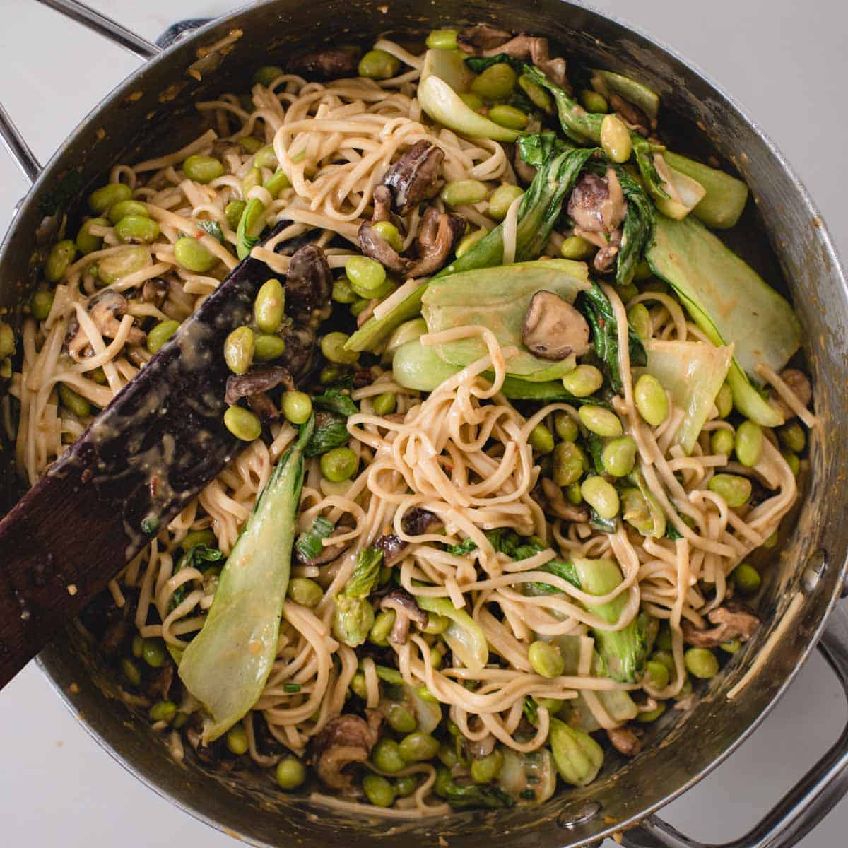noodles and veggies tossed with sauce in a skillet