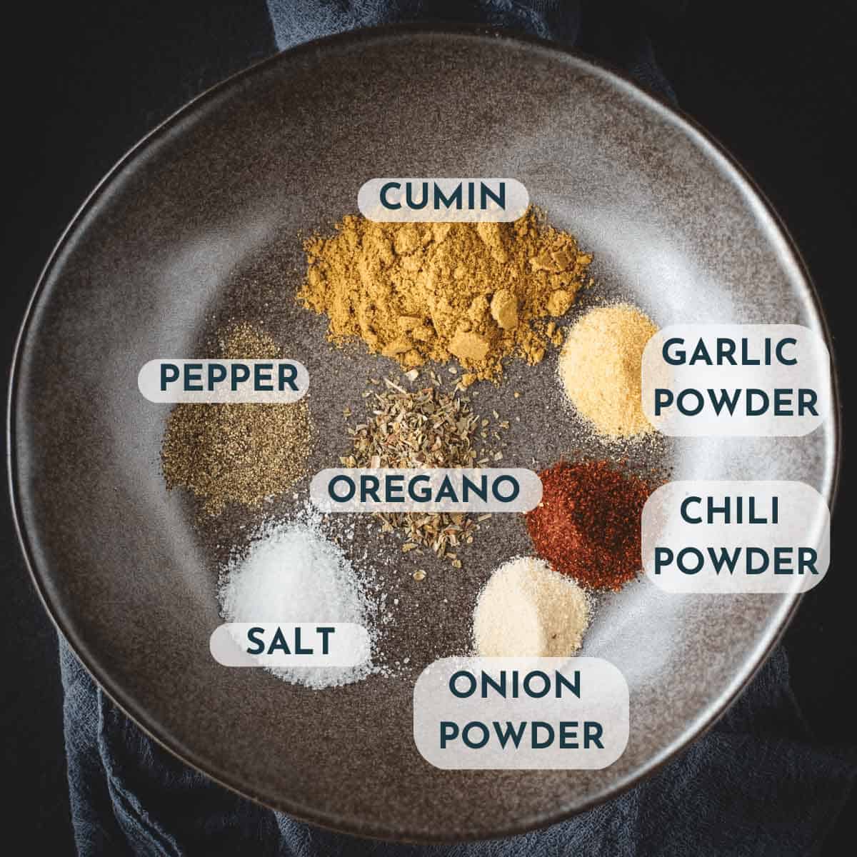pork tenderloin carnitas spice blend ingredients with text labels on top of each spice pile