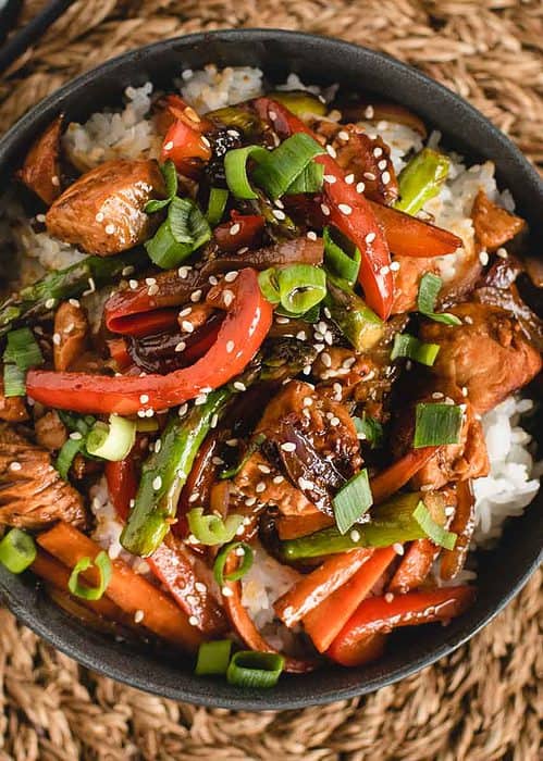 square overhead of bowl of salmon stir fry over rice