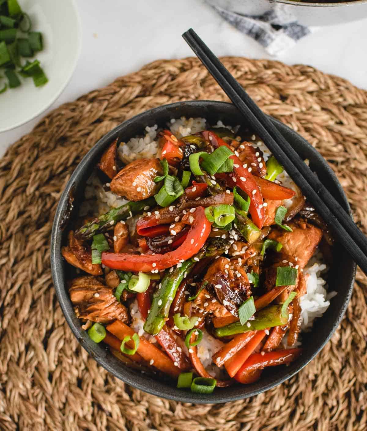 overhead of bowl of salmon stir fry over rice