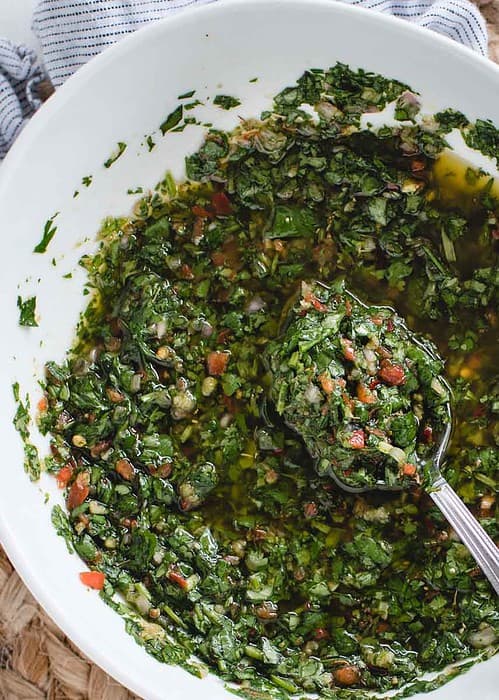 overhead angle of bowl of cilantro chimichurri with a spoonful in center focus