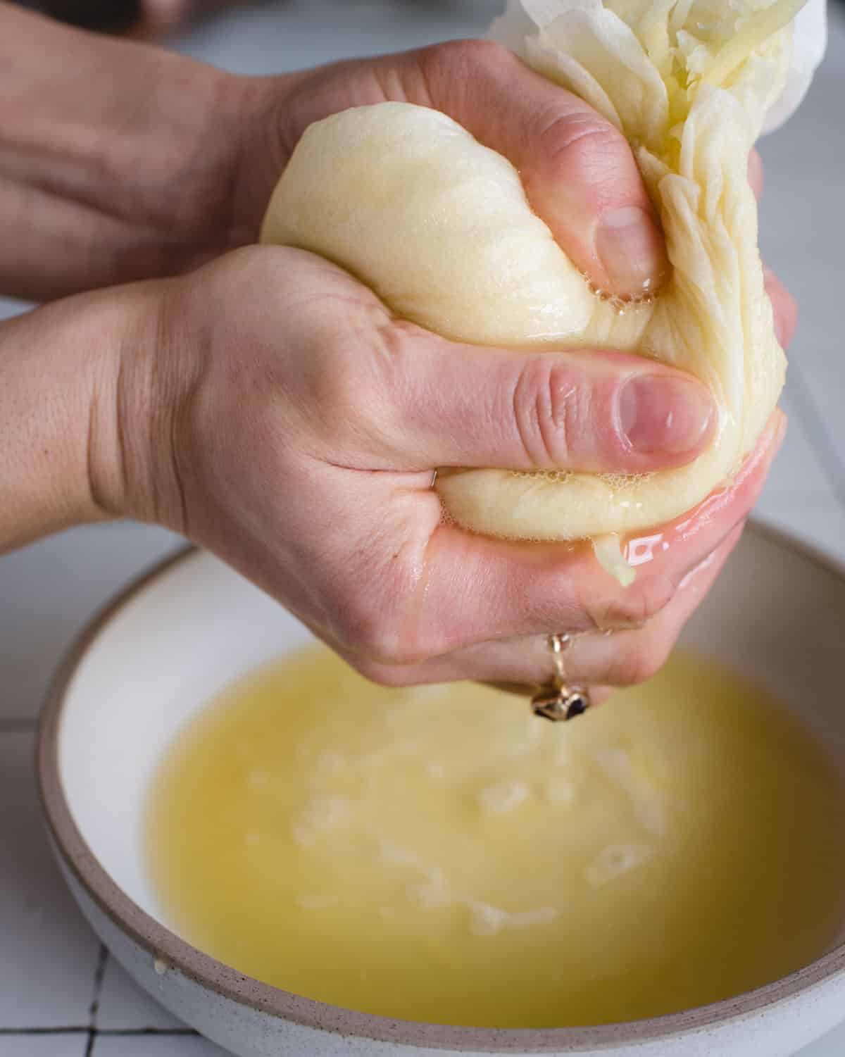 Hands squeezing the water out of shredded potato and onion